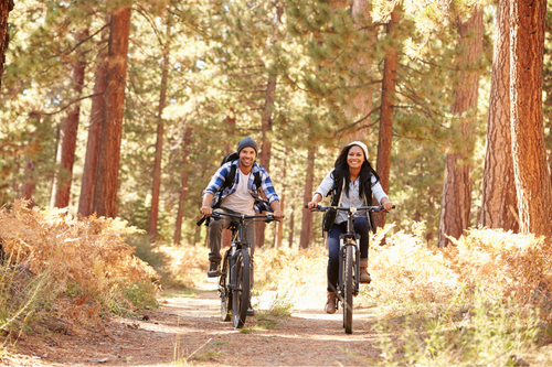 Cycling_through_woods_on_a_campsite_holiday_for_couples