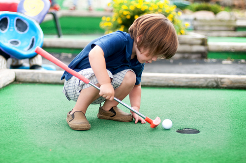 Small_boy_playing_mini_golf_at_a_mobile_hom_holiday_resort_in_Spain